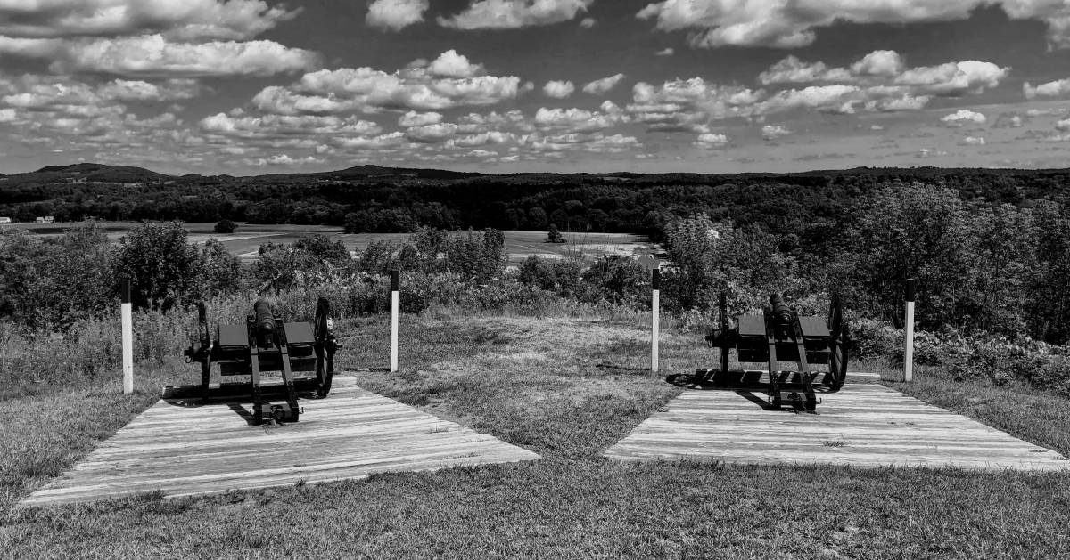 black and white photos of cannons on battlefield in park