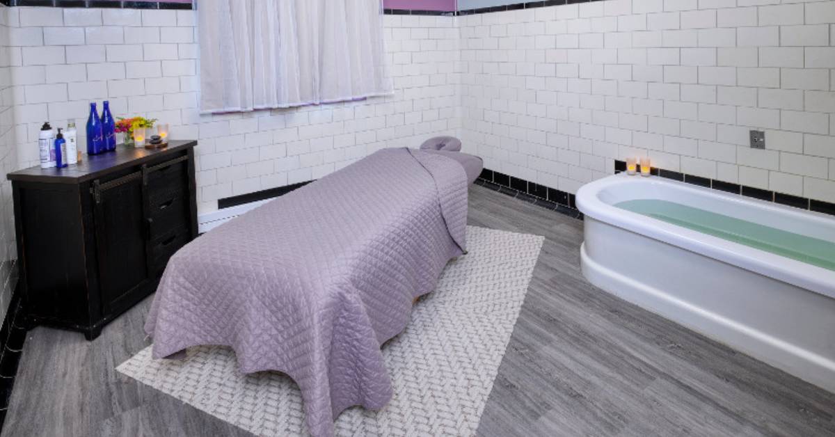 a purple spa bed with a dark brown cabinet nearby