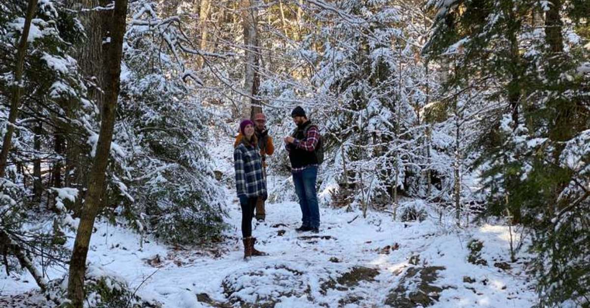 three people in a group on a snowy trail