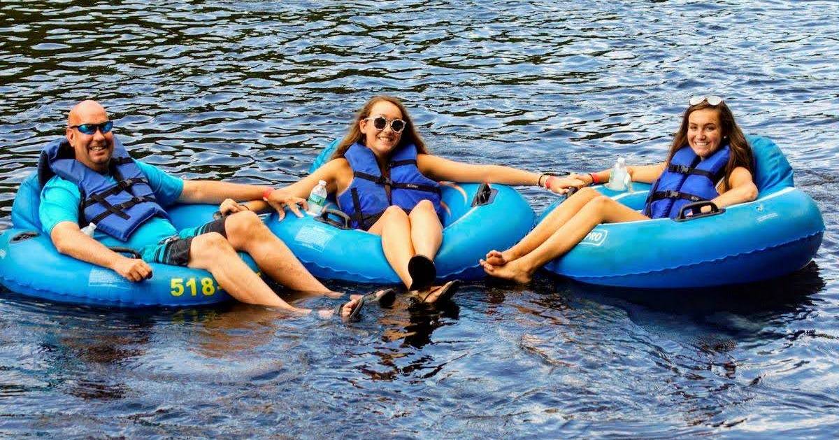 three people in blue tubes in the water