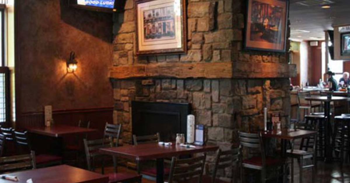 a stone fireplace near tables in a dining area