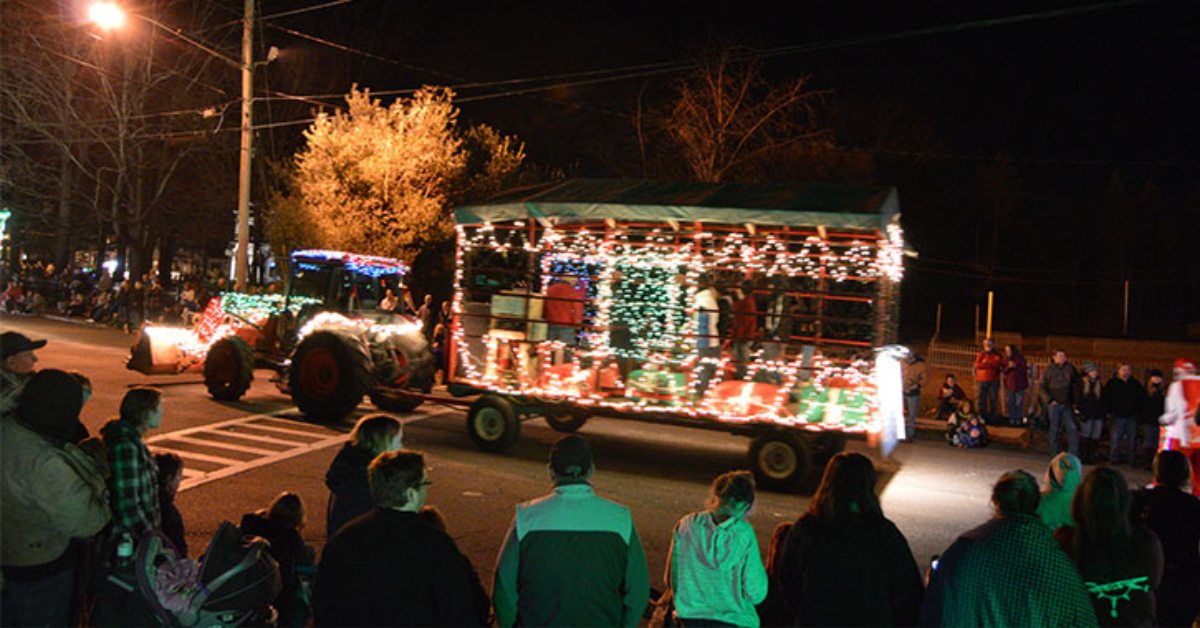 people watching a lighted tractor parade