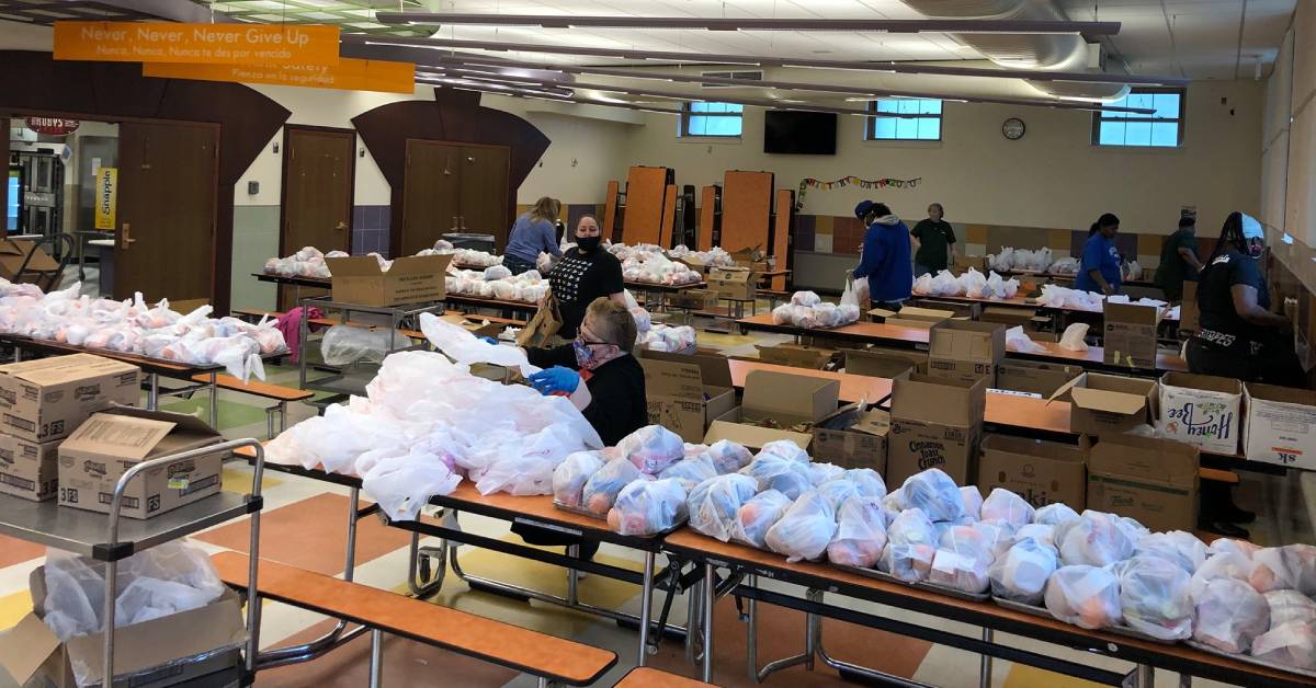 image of people in a large room with bags of goods