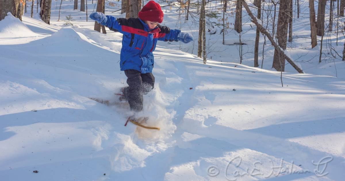 kid on snowshoes jumps in snow