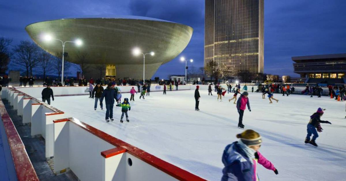 people ice skating outdoors in the evening during winter