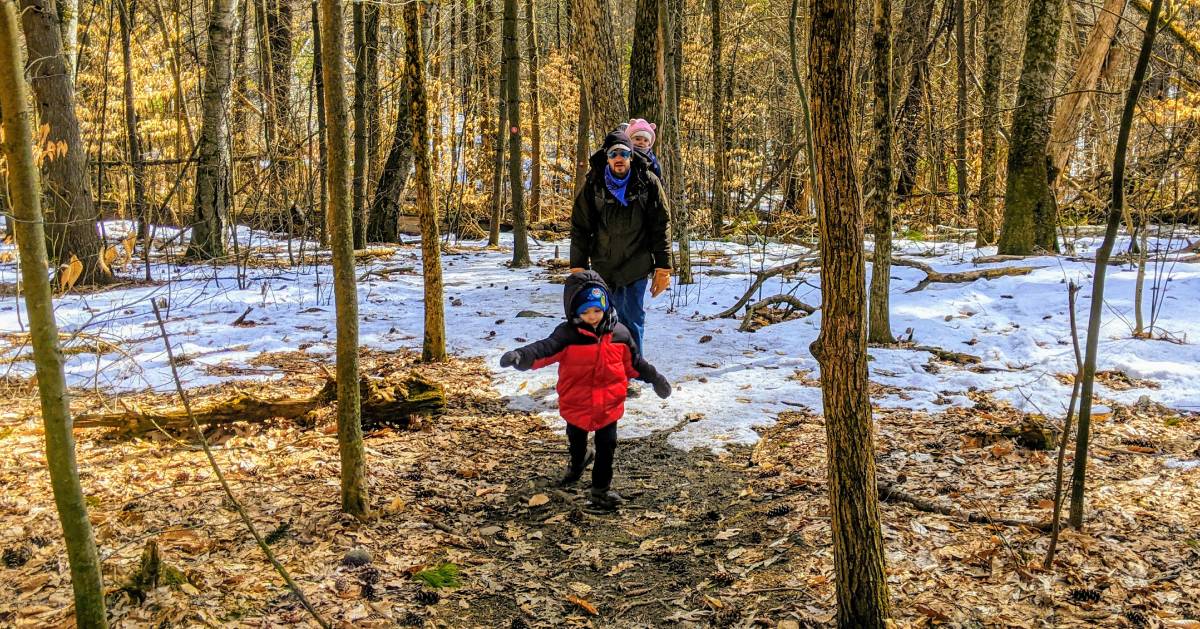 dad hiking with kids in woods in winter