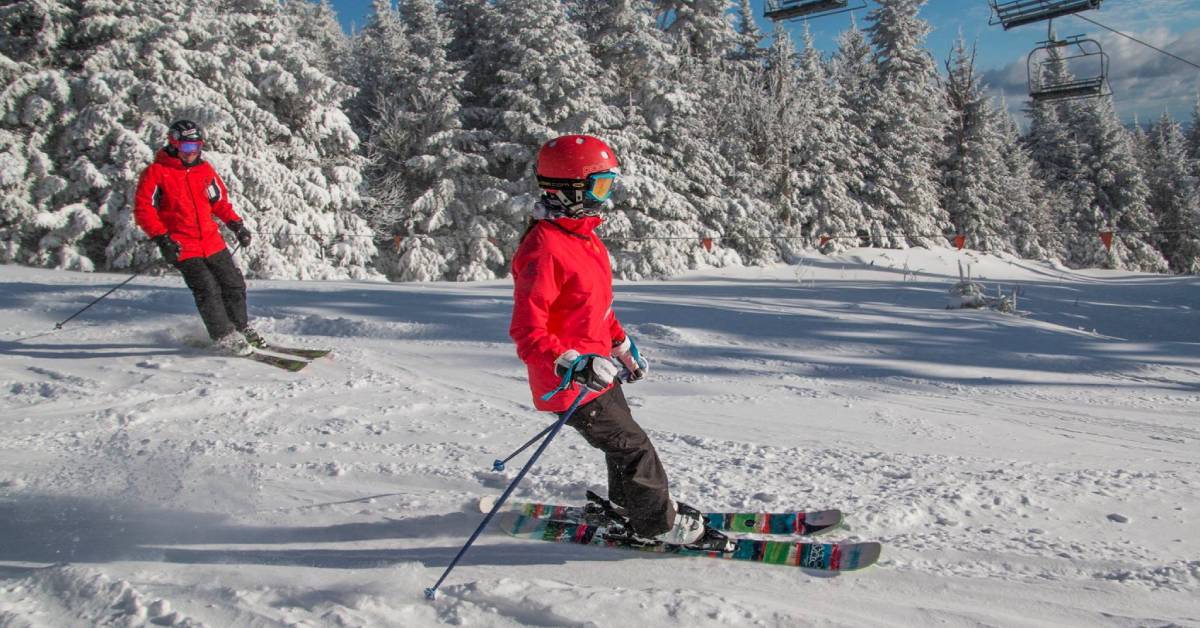 man and child in red winter coats skiing