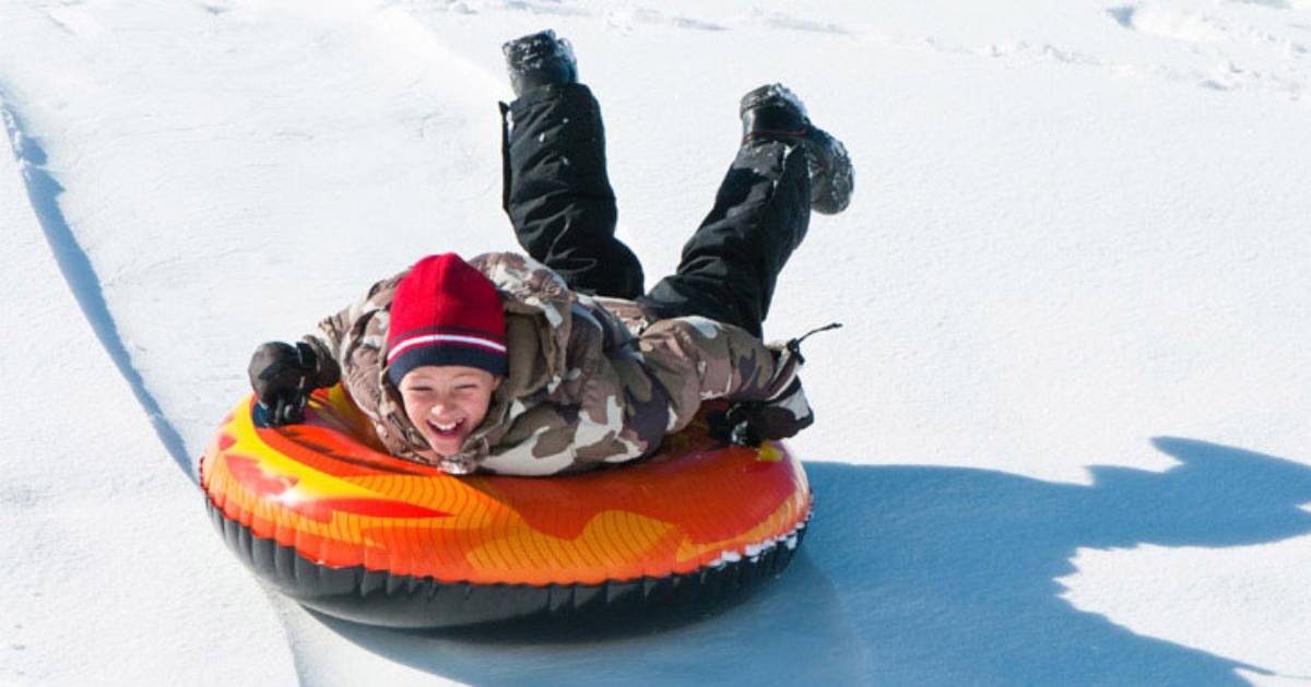 a boy snow tubing down a hill