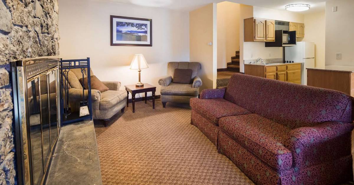 hotel suite with fireplace and couch and chairs