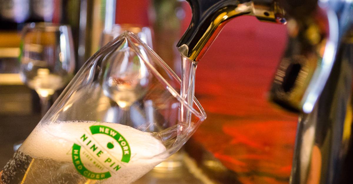 hard cider being poured from a tap into a glass