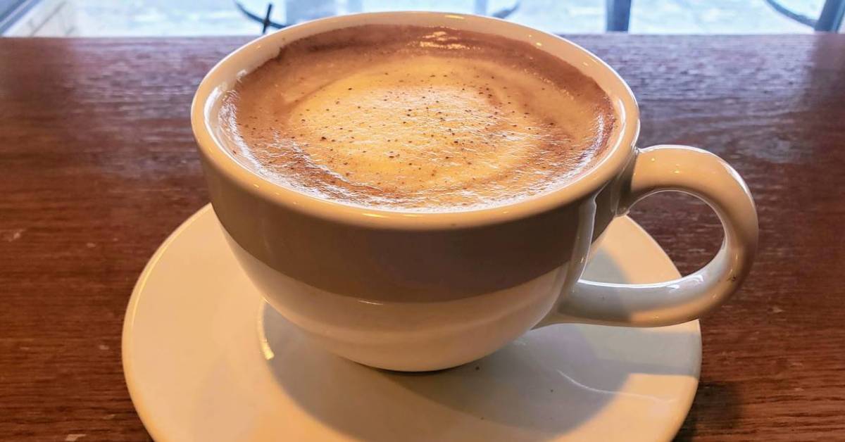 a cup of coffee with froth on top