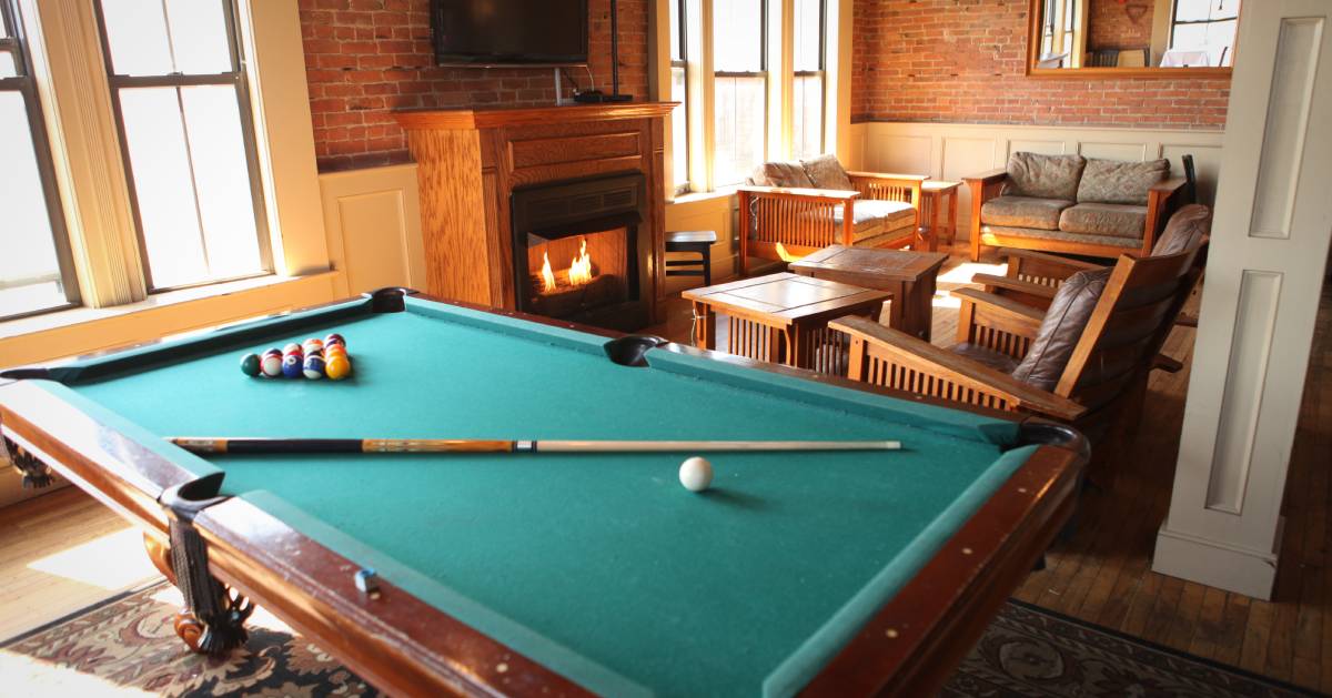 room with a pool table, a fireplace, and a lounge area