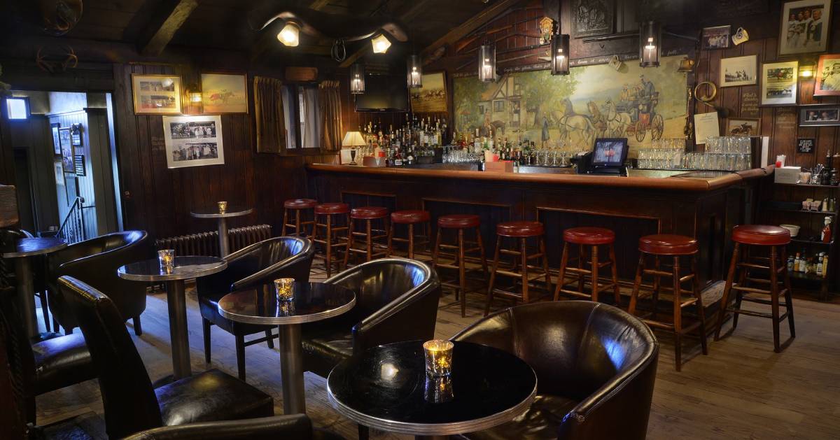 dining area with leather chairs and a bar area with wooden stools with red seats