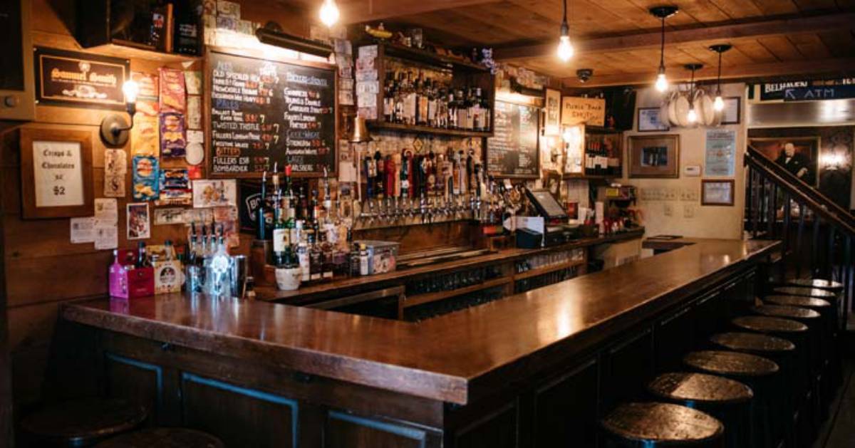 wooden bar with taps and bottles in the back