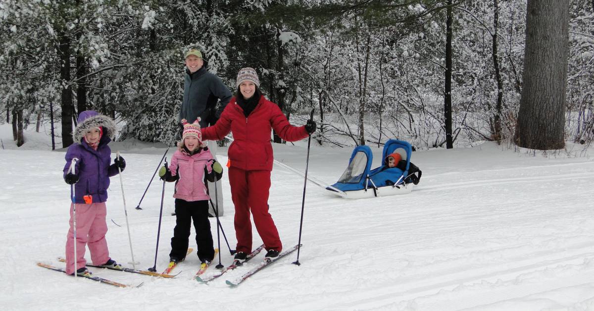 man, woman, two girls, and young boy in a sled outdoors