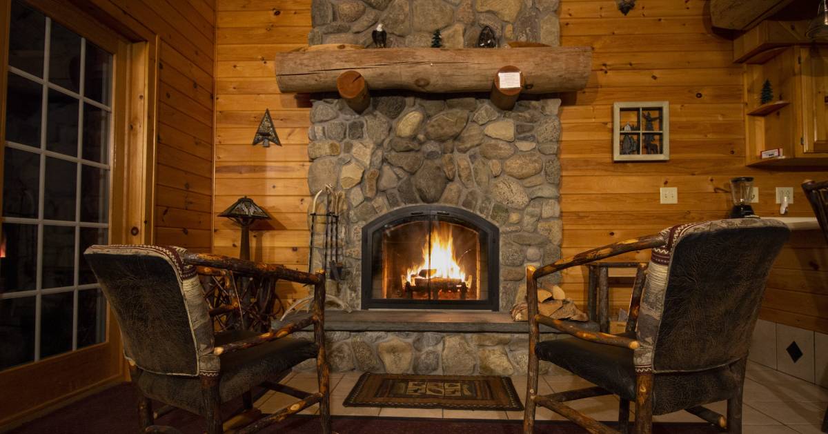 a living room in a cabin with a lit fire