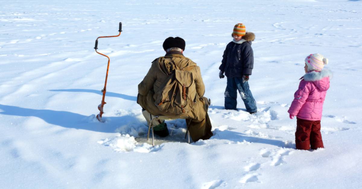 man with children ice fishing