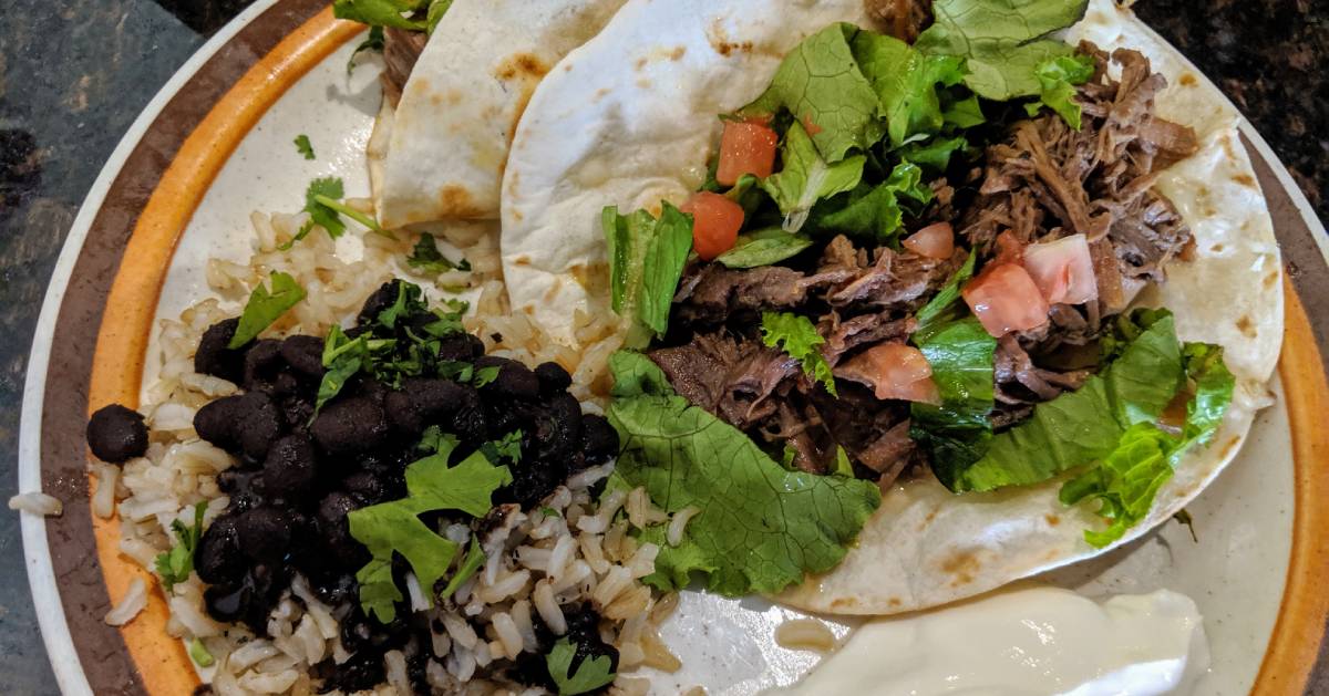 plate with beef taco and rice and beans