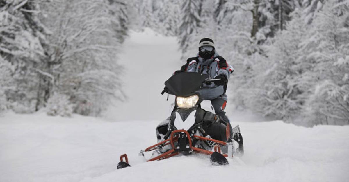 a snowmobiler on a snowy trail