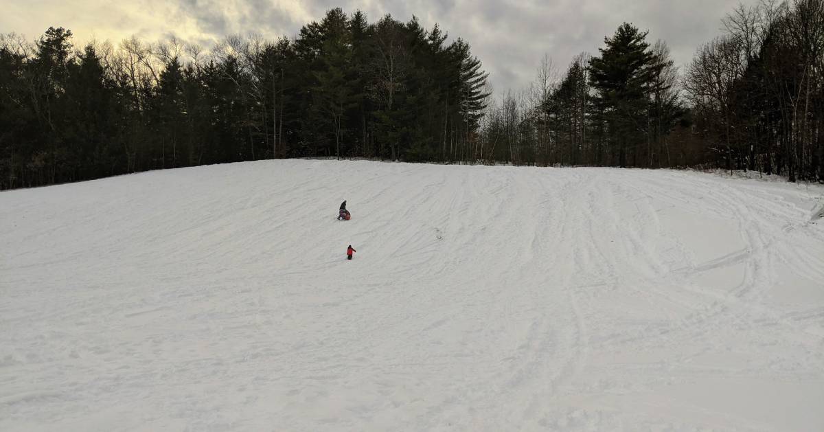 large tubing hill, two people on it