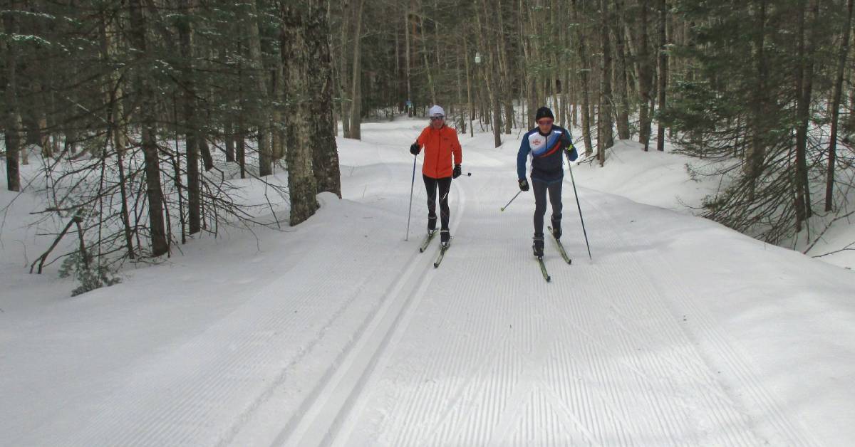 two cross country skiers on a groomed trail