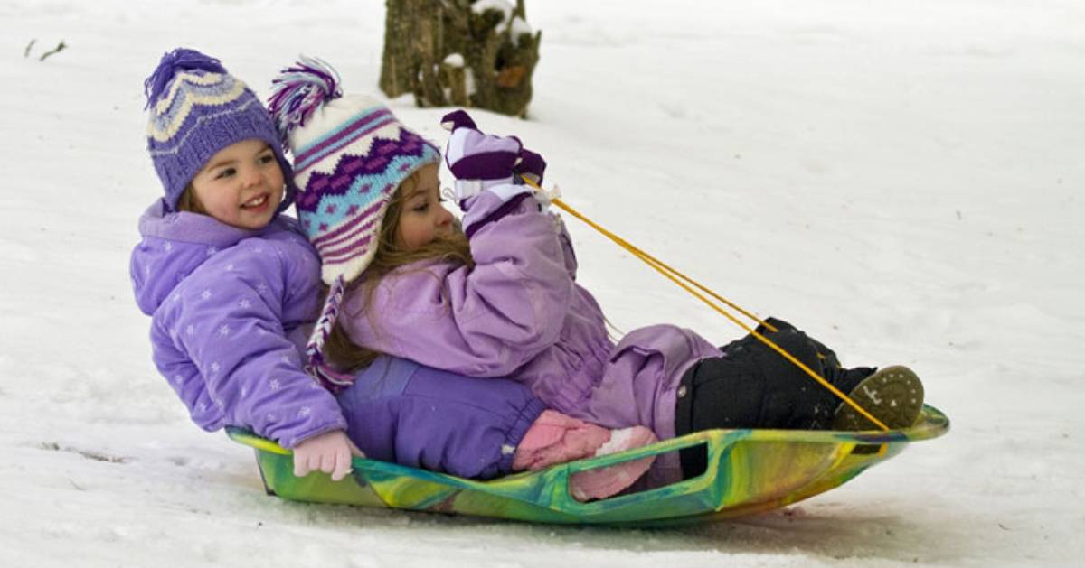 young kids sledding down a hill