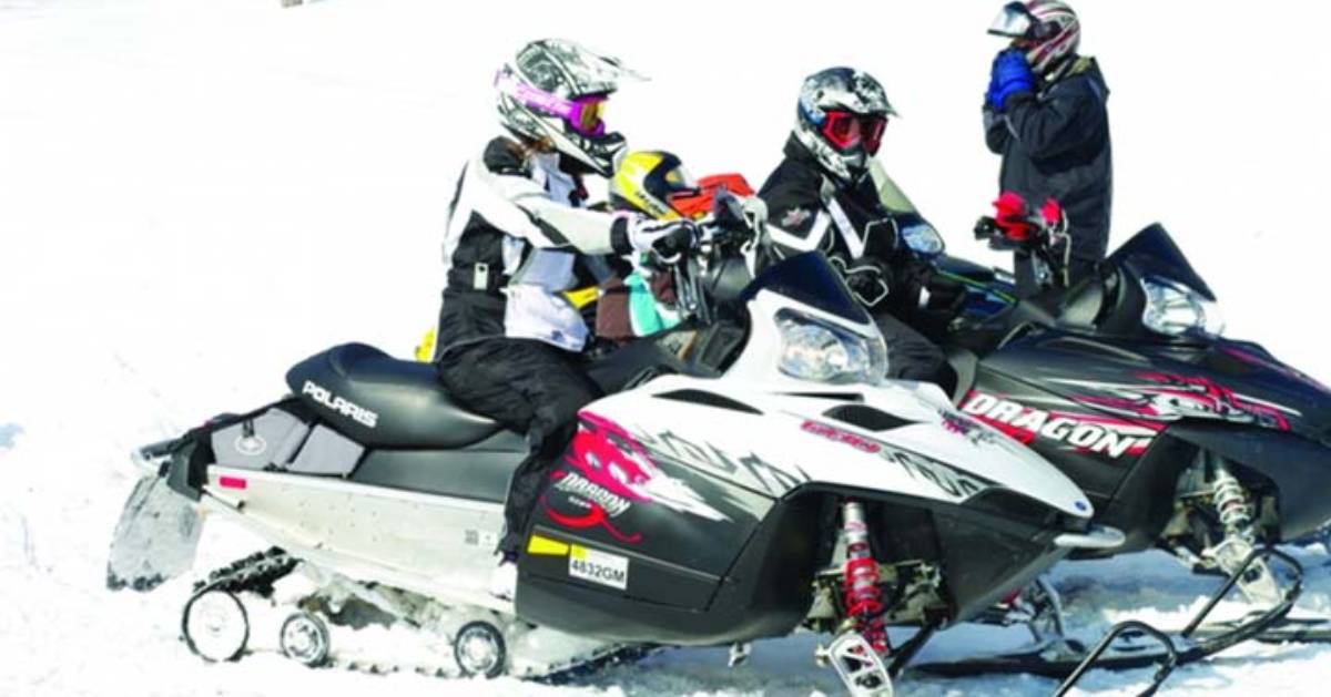 a small group of snowmobilers