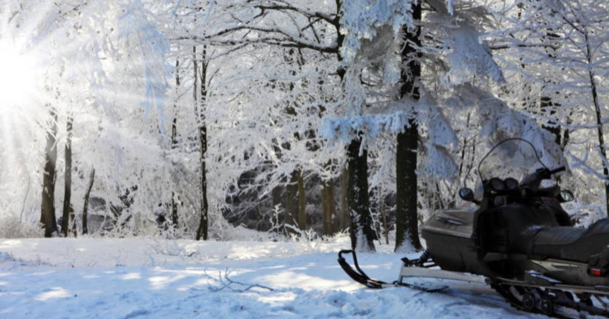 sun shining on snowmobile and trail