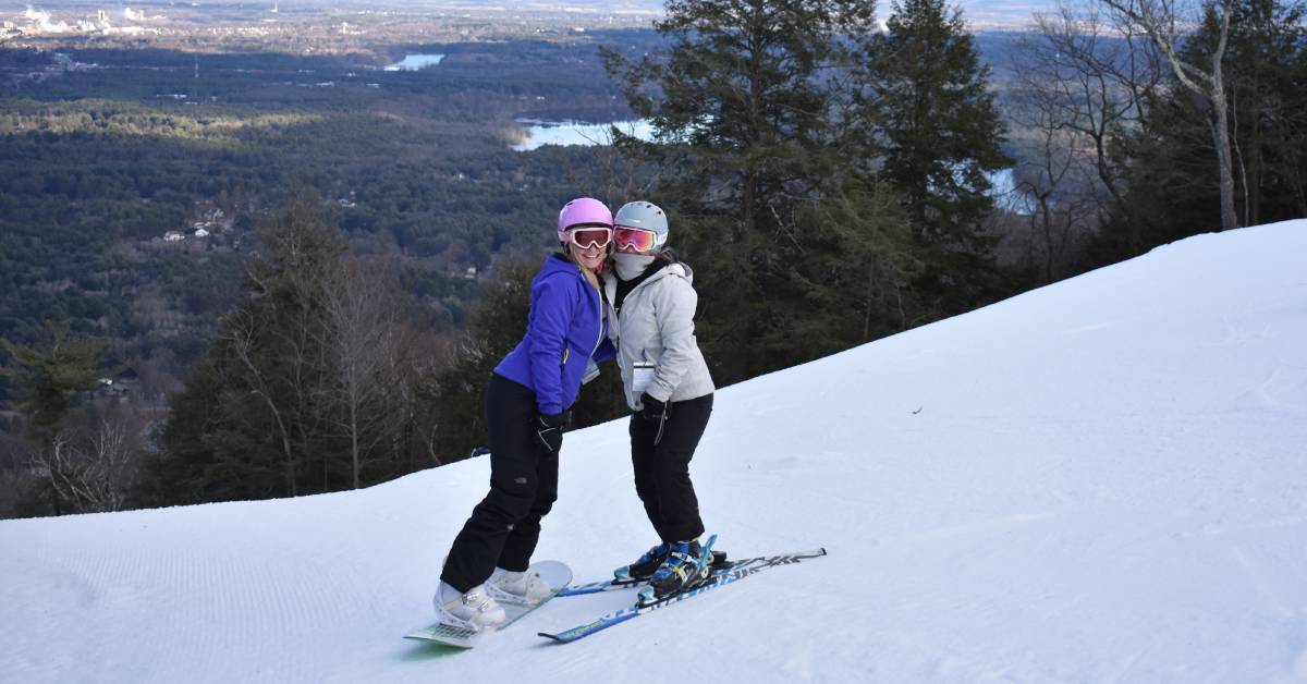 two female snowboarders on a snowy hill