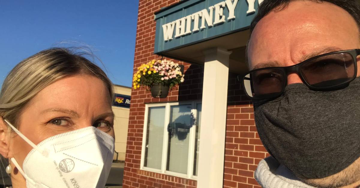 masked couple stands in front of Whitney Young