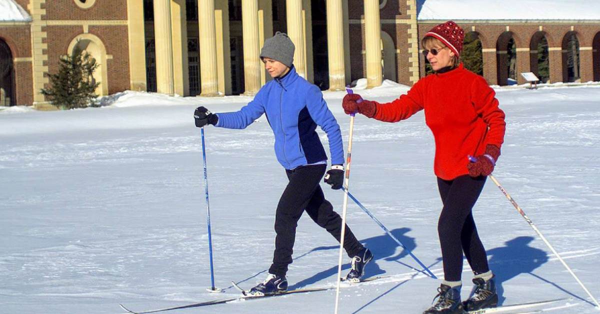 two people cross country skiing in a park