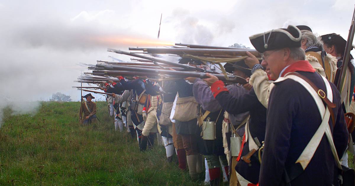 revolutionary war recreationists firing muskets
