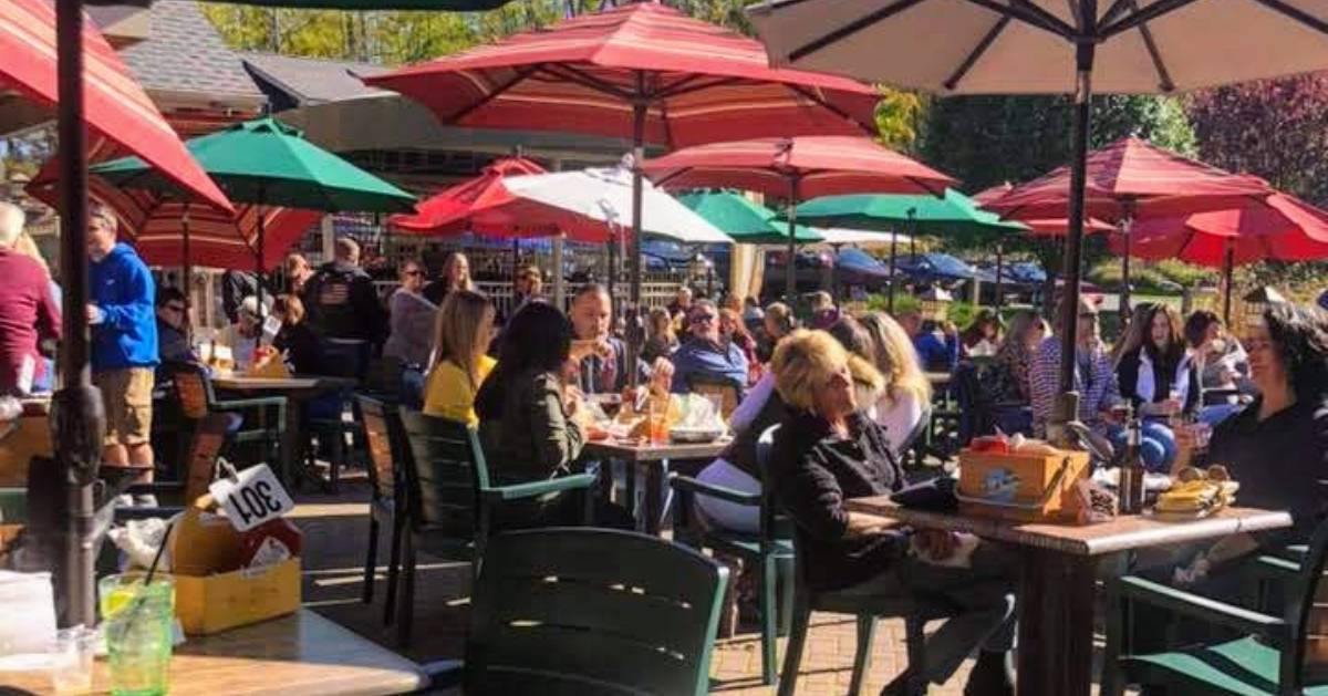 people dining on a patio with umbrellas