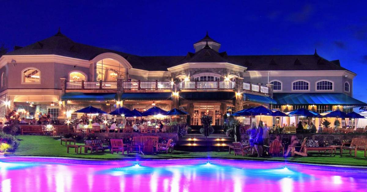 elaborate patio dining at night, purplish lights, there's water