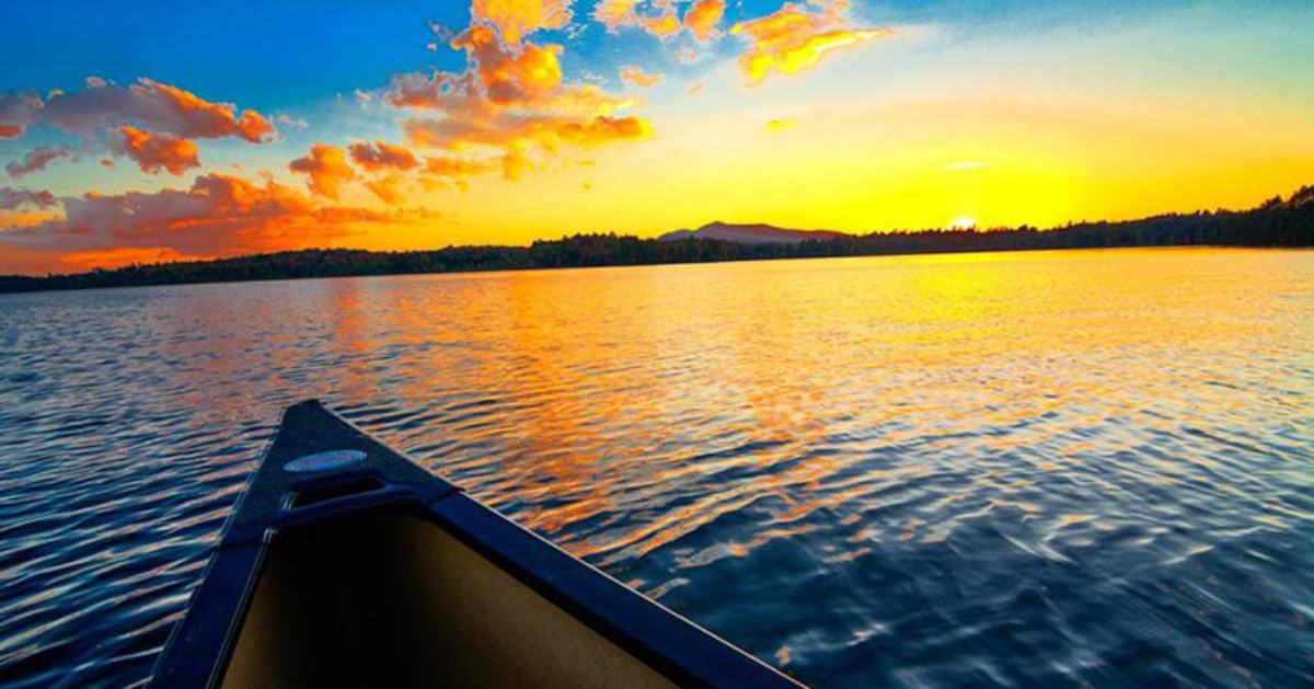 canoe in water at sunset