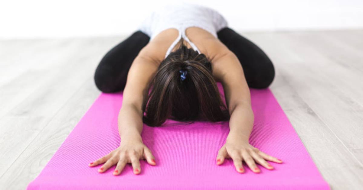woman doing yoga on pink mat