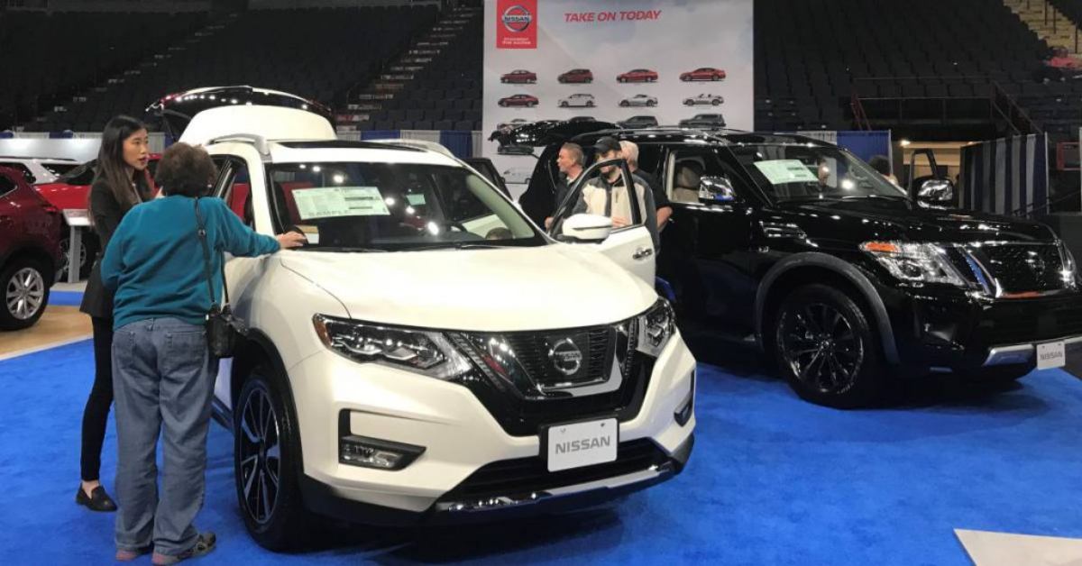 people checking out new cars at an auto show