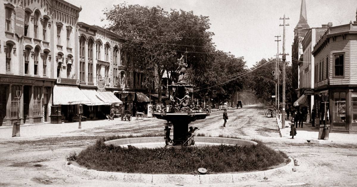 black and white photo of street and fountain in Glens Falls