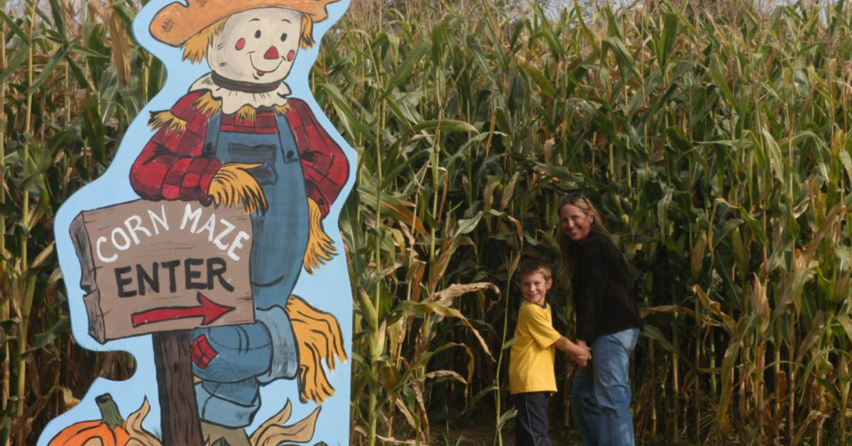 corn maze sign and two people