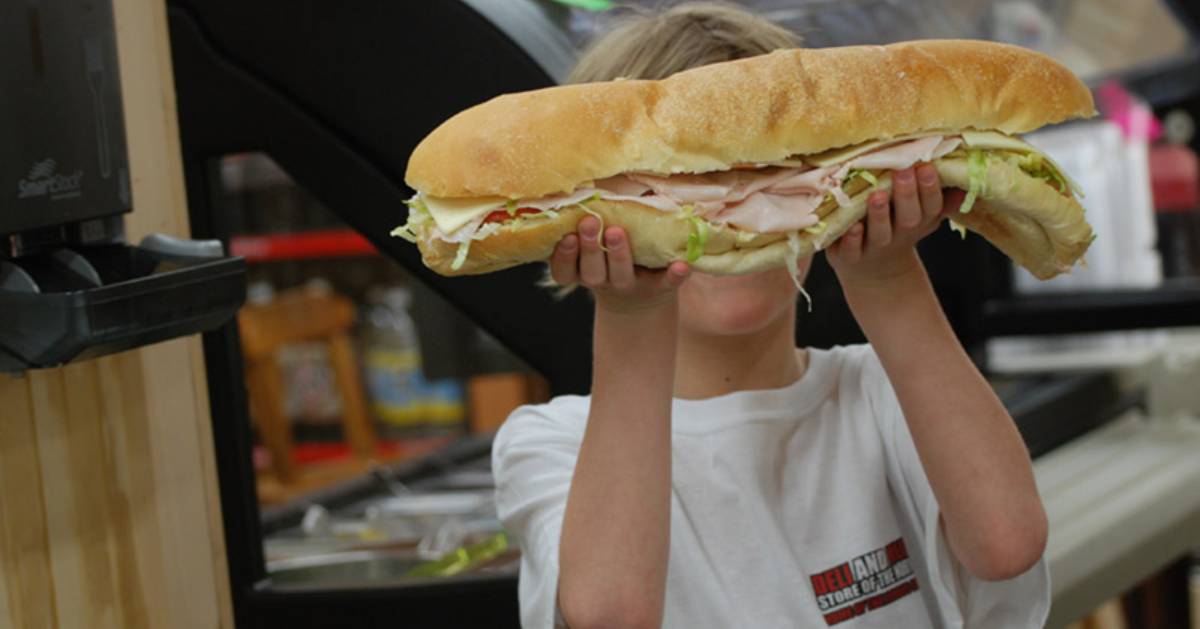 boy holding up a large sub