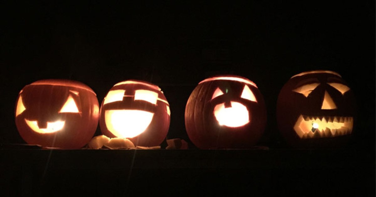 four jack o lanterns in the darkness