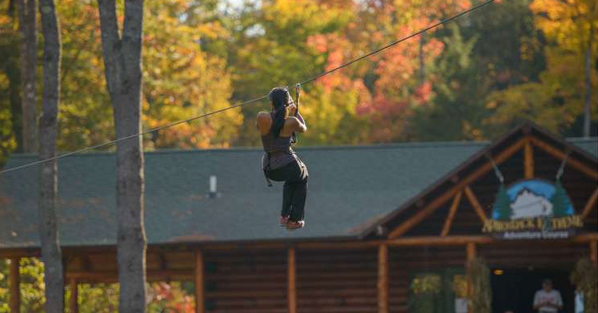 woman ziplining in the fall
