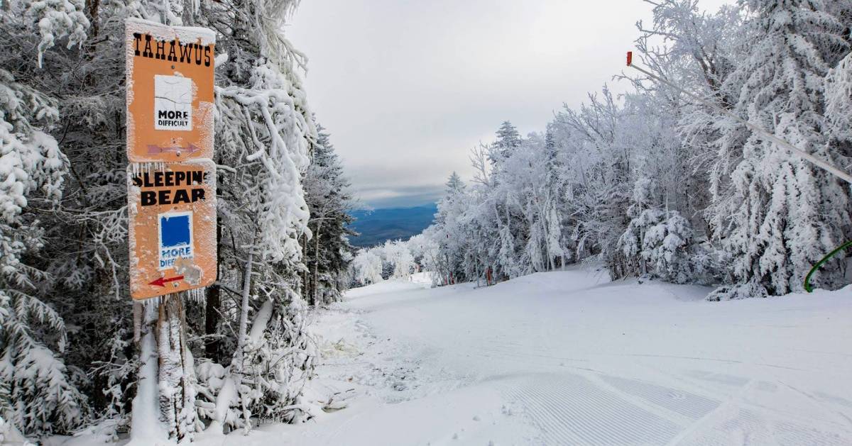 a skiing mountain with a trail sign