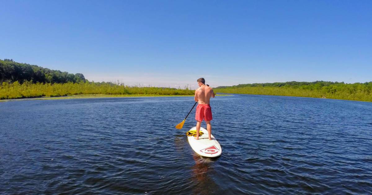a guy standup paddleboarding