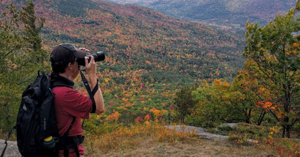 man looking at mountain view through binoculars