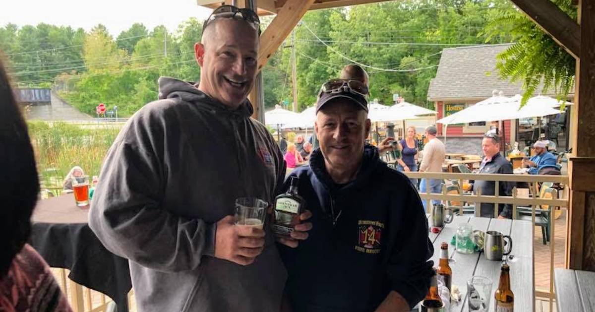 two guys drinking on a patio at a restaurant