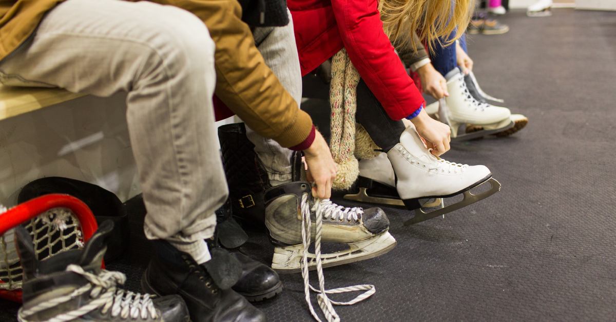 people lacing up ice skates indoors