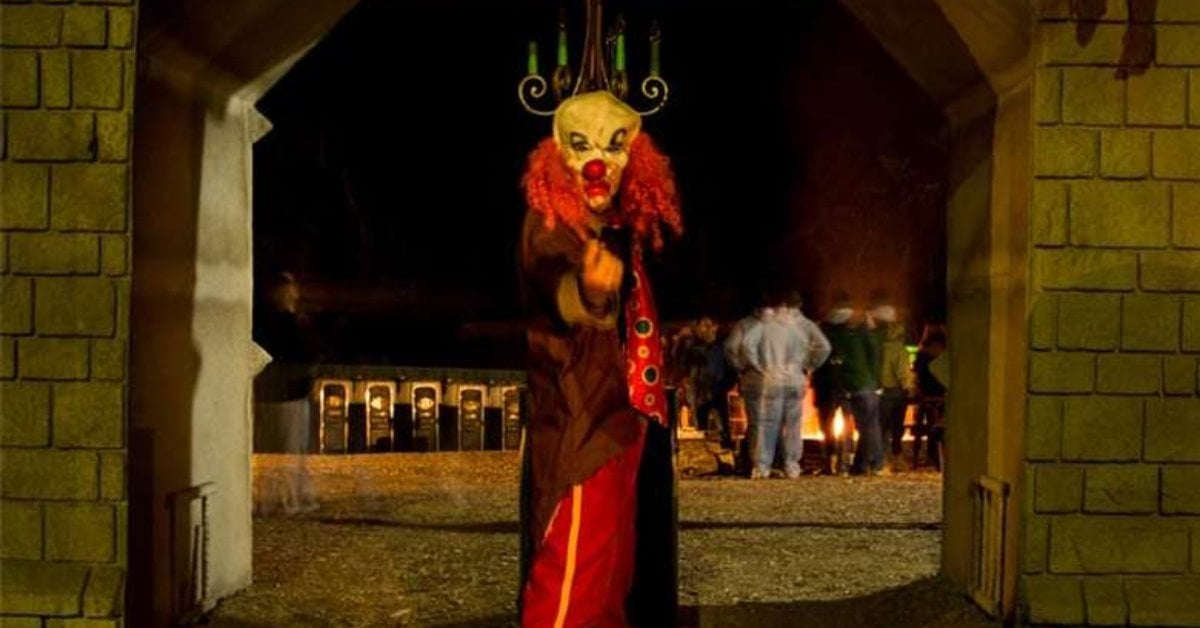 a scary clown in field at halloween attraction