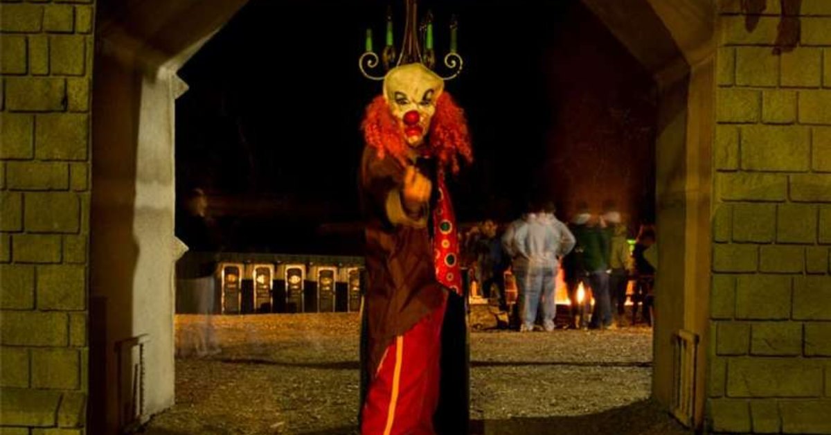 a scary clown in field at halloween attraction