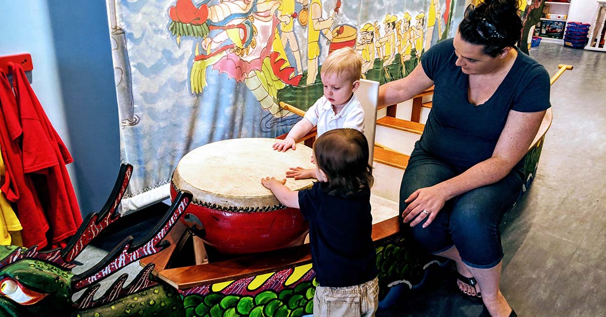 woman with two kids at a museum